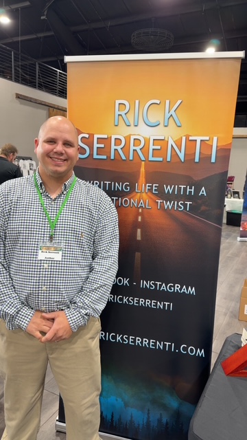 Rick Serrenti standing by his banner at the Books Books Books Event